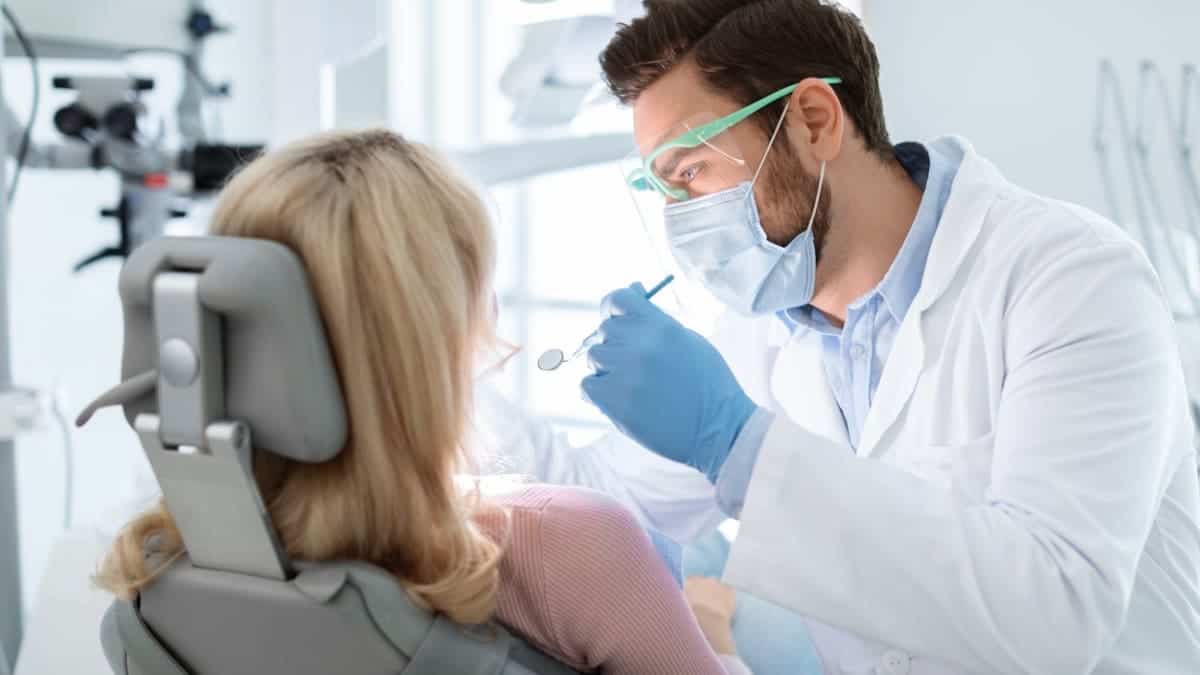 Patient receiving professional teeth whitening with a laser device Eastbourne